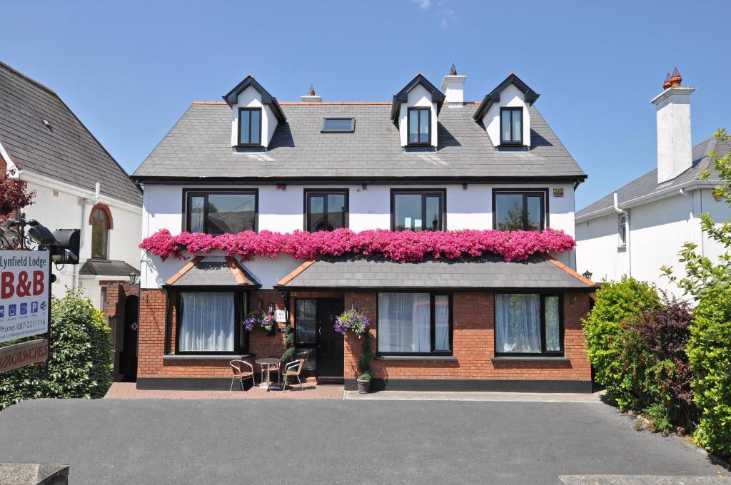 une maison avec des fleurs roses sur son côté dans l'établissement Lynfield B&B, à Galway