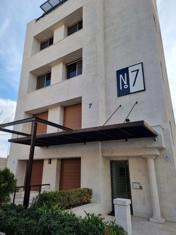 un bâtiment avec un panneau sur son côté dans l'établissement No7 Boutique Apartments, à Amman