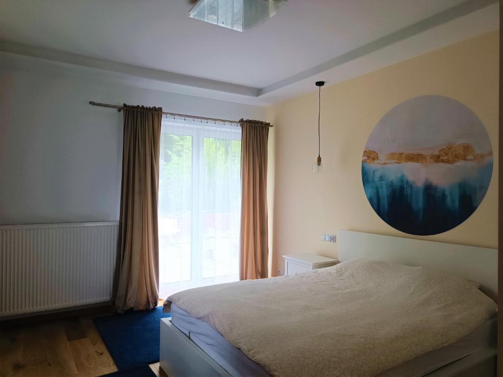 ein Schlafzimmer mit einem Bett und einem großen Fenster in der Unterkunft Rowerowe Wierzchowie in Wierzchowie