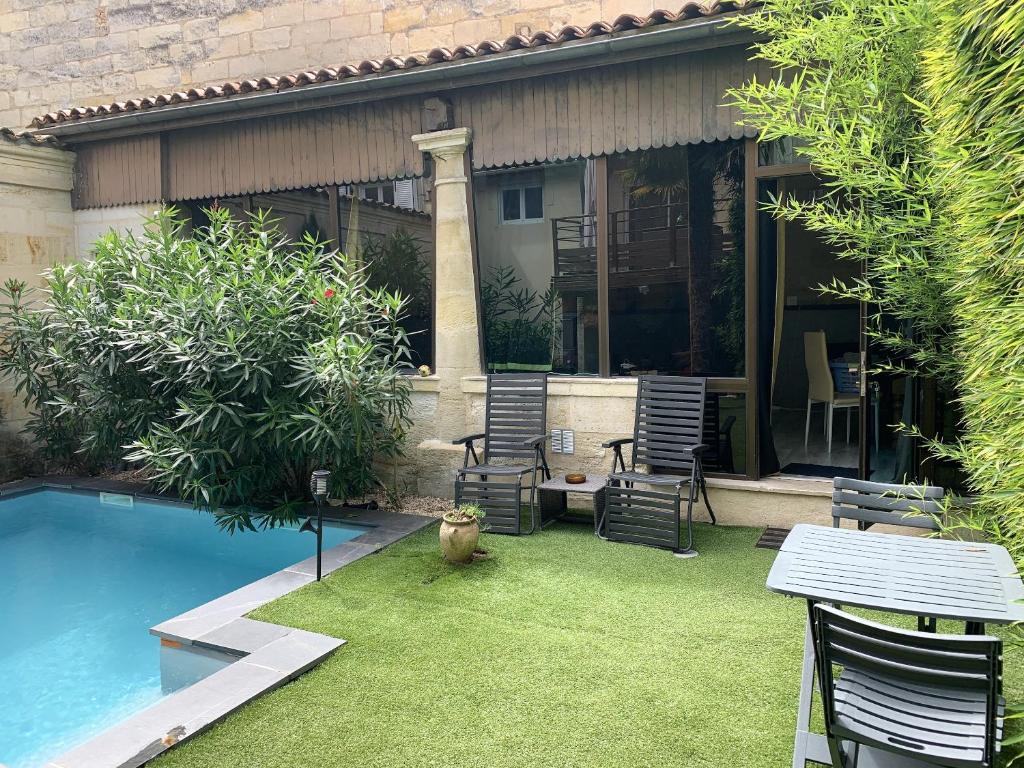 利布爾訥的住宿－Maison d'une chambre avec piscine privee jardin clos et wifi a Libournea，一个带桌椅的庭院和一个游泳池