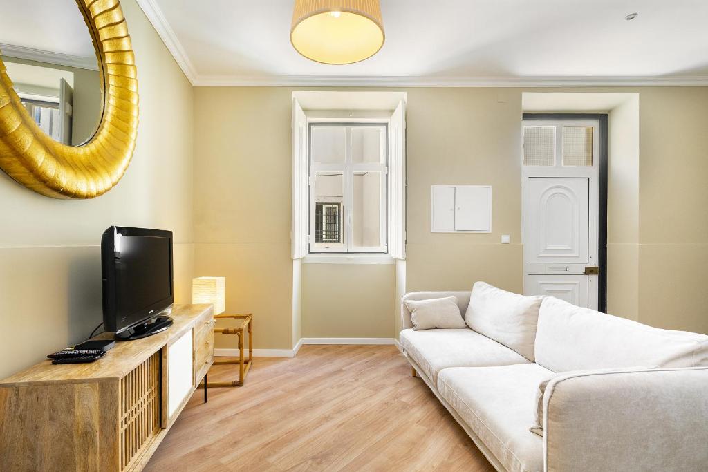 - un salon avec un canapé blanc et un miroir dans l'établissement WHome Urban Comfort: 1-BR near Airport & Train Station, à Lisbonne