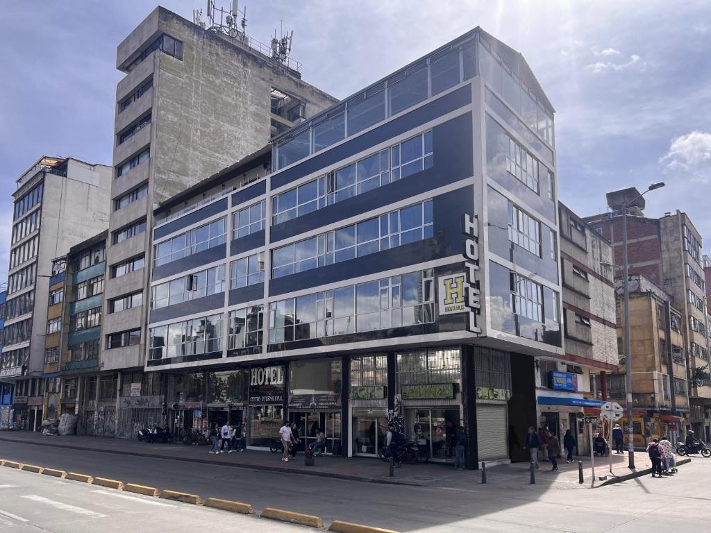 un edificio alto en una calle de la ciudad con gente de pie fuera en Hotel HILLS BOGOTA en Bogotá