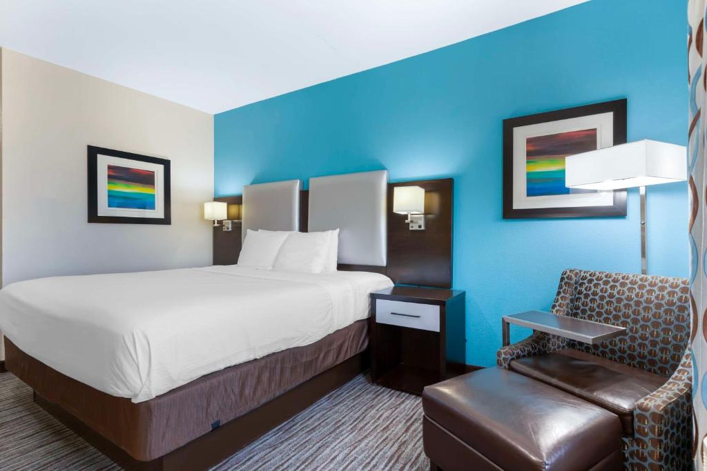 a hotel room with a bed and a chair at Best Western Plus Pleasanton Hotel in Pleasanton