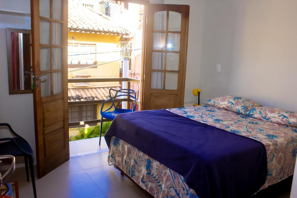 a bedroom with a bed and a balcony with a view at Suíte na vila de Praia do Forte in Praia do Forte