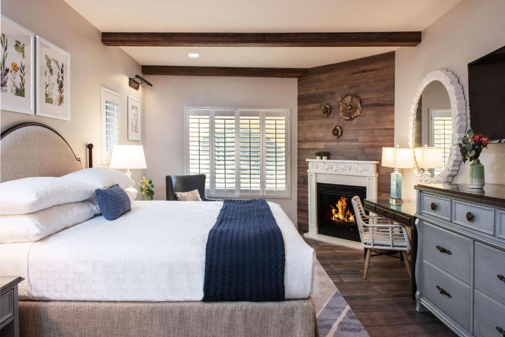a bedroom with a large bed and a fireplace at The Lodge at Healdsburg, Tapestry Collection by Hilton in Healdsburg