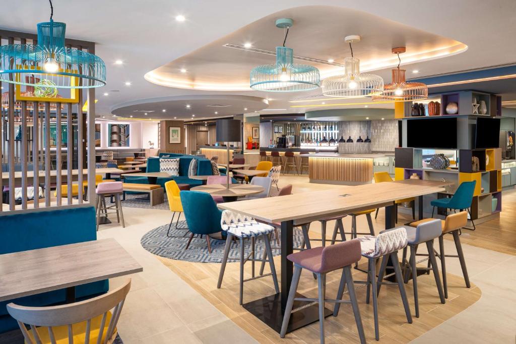 a restaurant with tables and chairs and a bar at Hampton By Hilton London City in London
