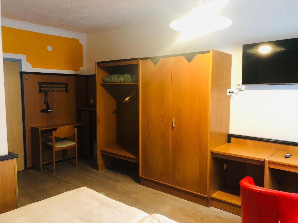 a room with a tv and a desk and a cabinet at Holmes Café & Pension in Engelhartszell