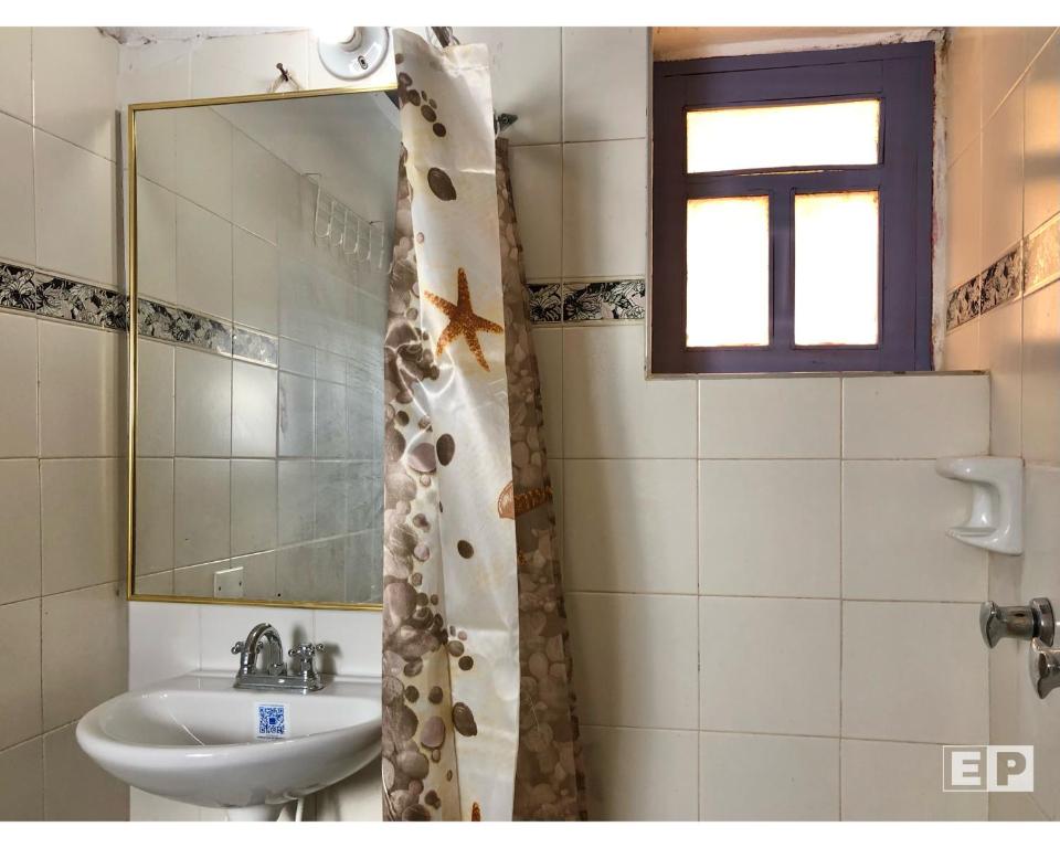 La salle de bains est pourvue d'un lavabo et d'un miroir. dans l'établissement Beija Flor Hostel, à Villa de Leyva