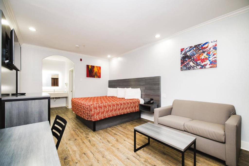 um quarto de hotel com uma cama e um sofá em Palace Inn 290 - Fairbanks em Houston
