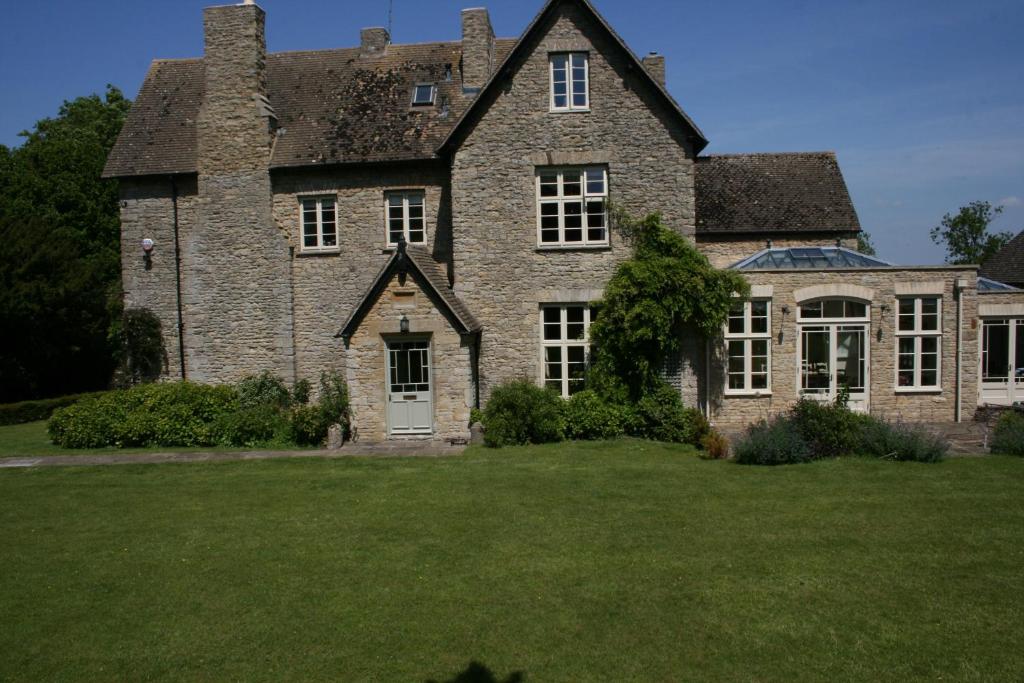 uma grande casa de pedra com um grande quintal em Helmdon House Bed and Breakfast em Helmdon