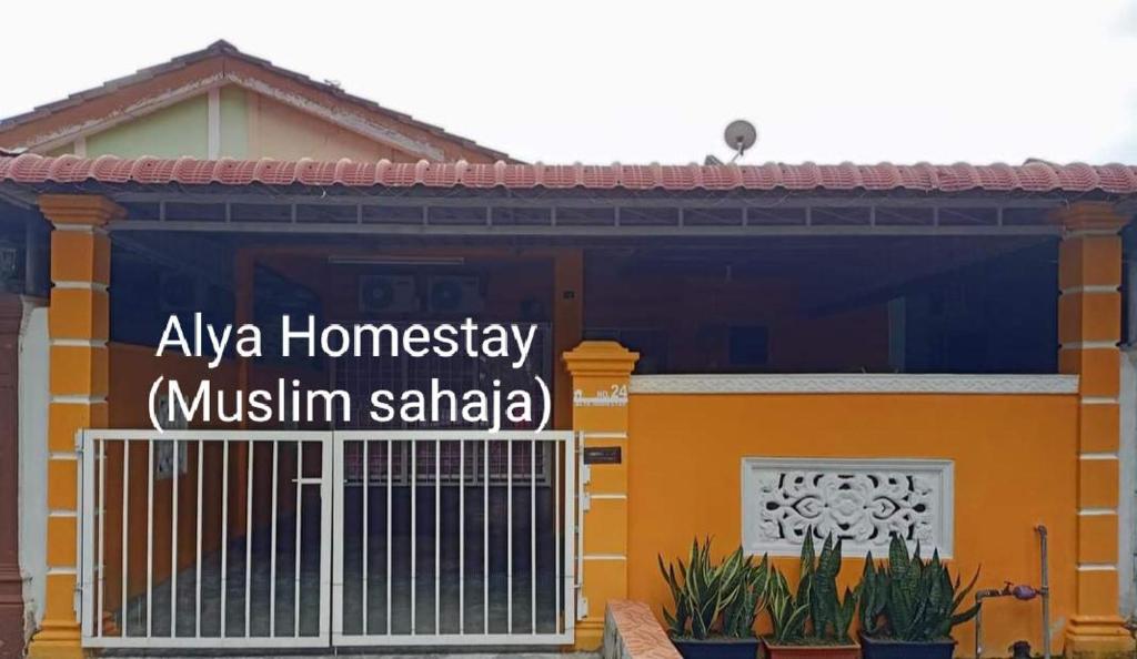 ein Haus mit einem Schild davor in der Unterkunft ALYA HOMESTAY TAMAN TAMBAK PAYA MURNI in Malakka