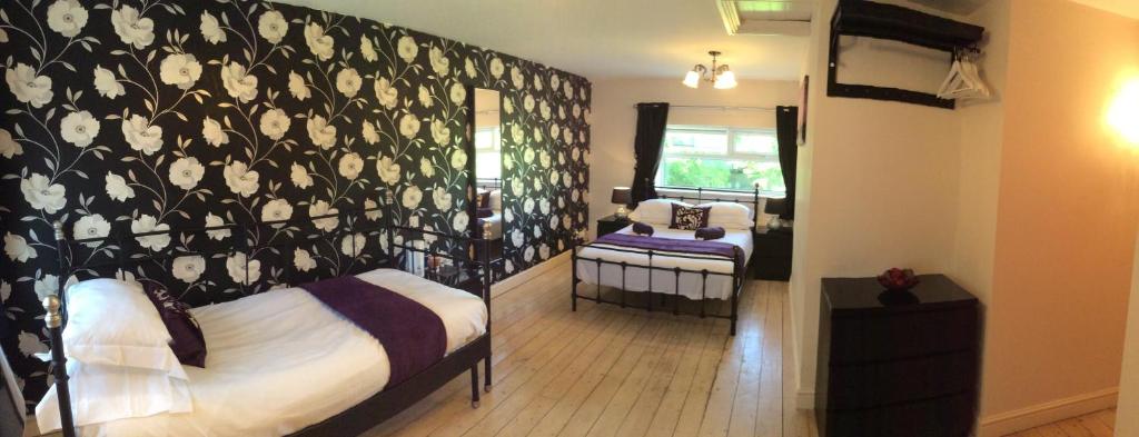 a bedroom with a black and white patterned wall at The Golden Lion Hotel in Middlewich