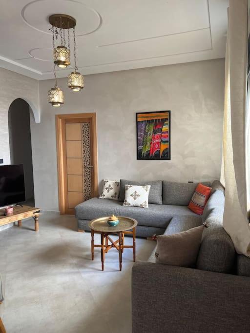 a living room with a couch and a table at Logement moderne et neuf entièrement équipé in Fez