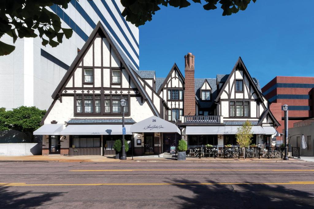 un bâtiment avec des toits noirs et blancs dans une rue dans l'établissement Seven Gables Inn, St Louis West, a Tribute Portfolio Hotel, à Saint-Louis