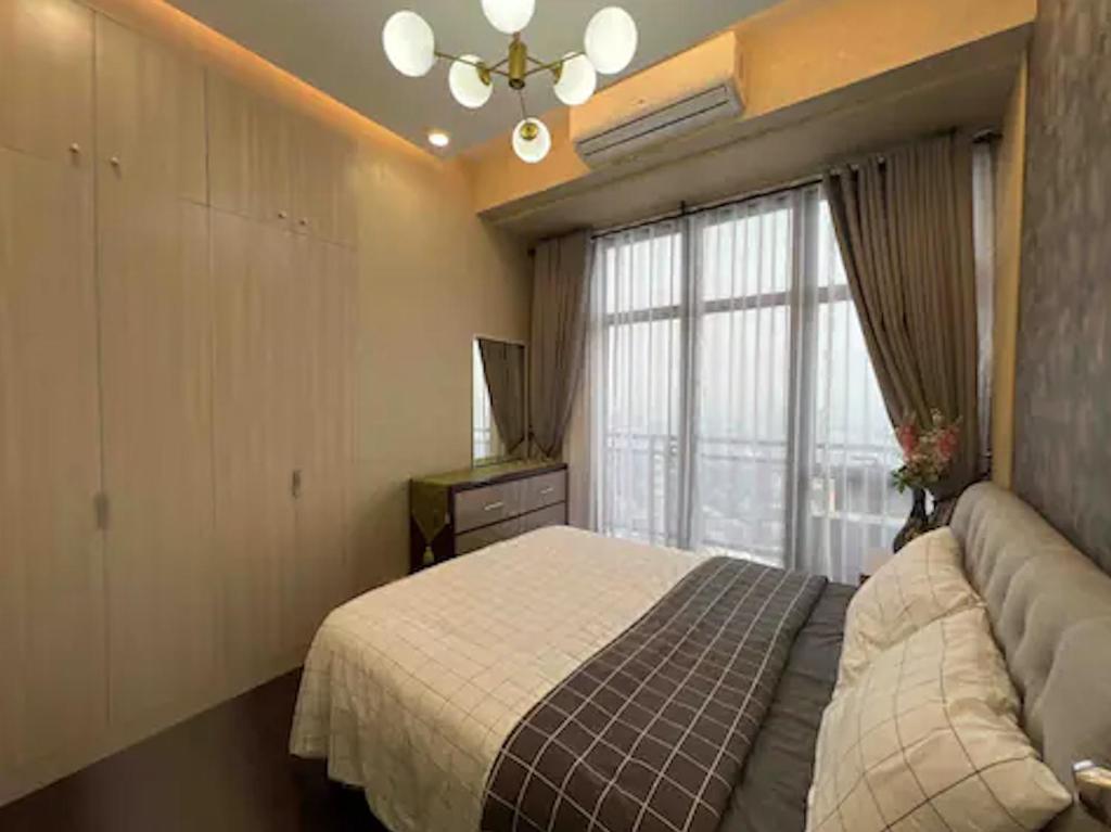 1 dormitorio con cama, sofá y ventana en Lovely 45 sqm 1-Br Knightsbridge Residences Wi-Fi/Netflix/HBO en Manila