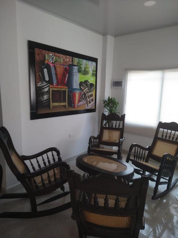 una stanza con sedie e tavolo e un dipinto sul muro di Casa Mompox a Mompós
