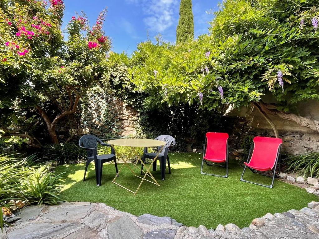 une table et quatre chaises dans un jardin dans l'établissement Maison Collioure, 3 pièces, 4 personnes - FR-1-309-368, à Collioure