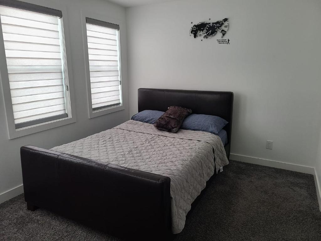 溫尼伯的住宿－Winnipeg Peace Home，一间卧室设有一张床和两个窗户。