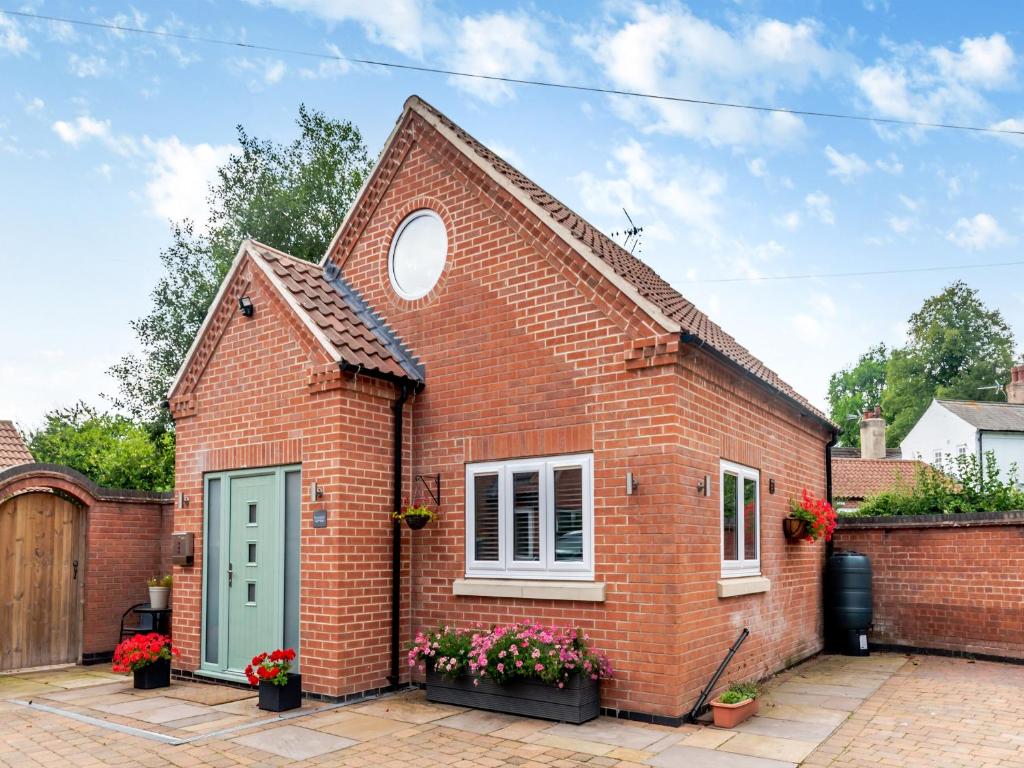a red brick house with a green door at The Retreat - Uk45099 in Kirklington