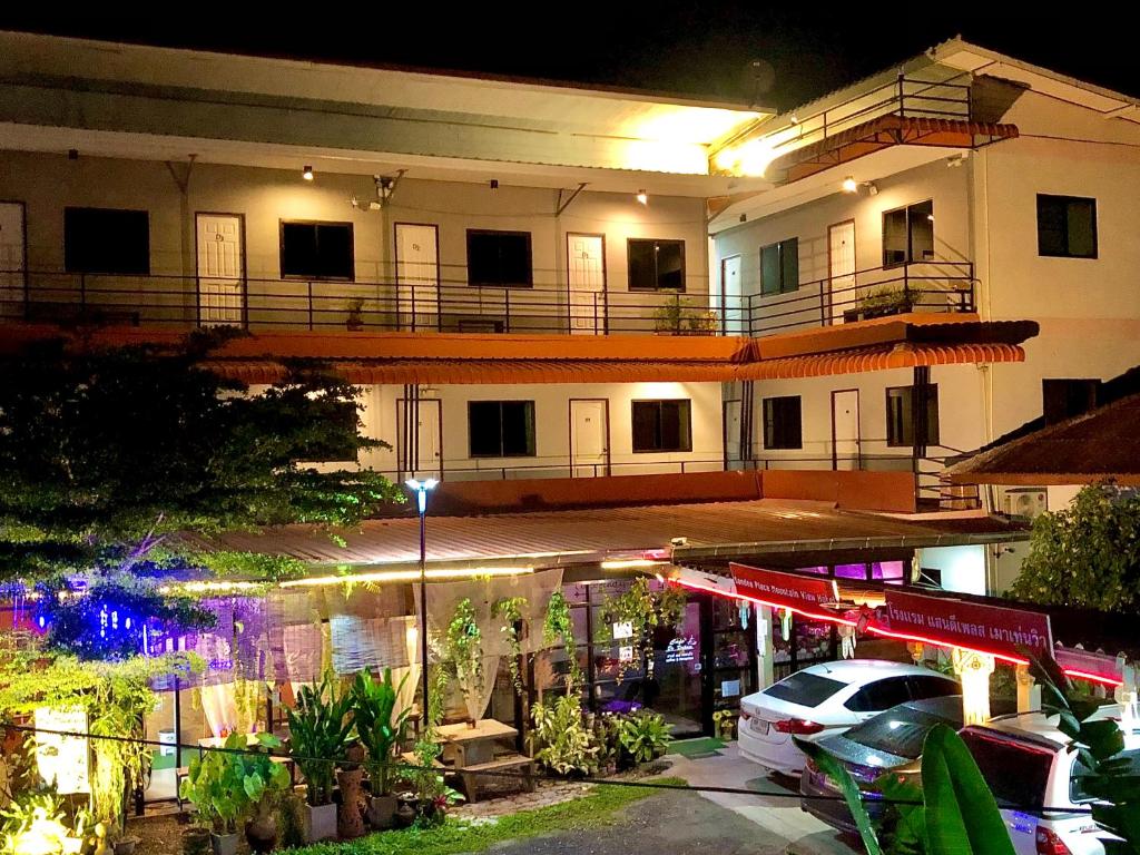 a building with a car parked in a parking lot at โรงแรมแสนดีเพลส เมาเท่นวิว จอมทอง in Chom Thong