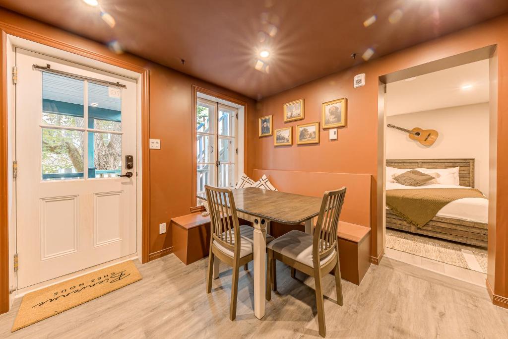 a dining room with a table and chairs and a bed at Quebec City 2 Bedroom Treasure in Quebec City