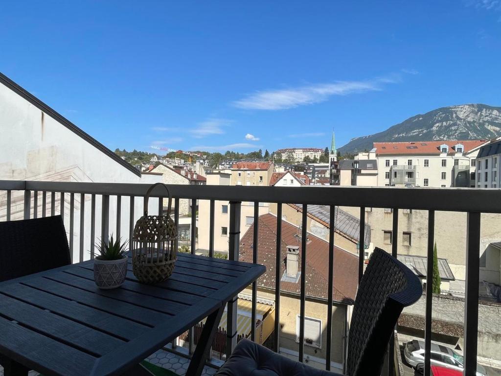 un balcon avec une table et une vue sur une ville dans l'établissement Studio lumineux avec balcon et parking - Animaux acceptés - FR-1-555-93, à Aix-les-Bains