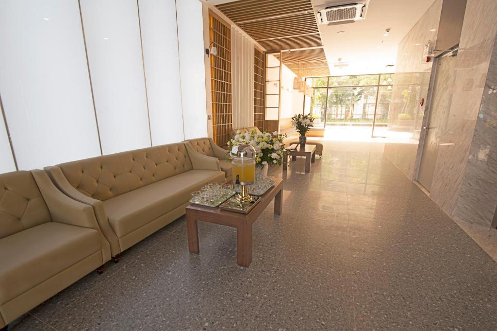 uma sala de estar com um sofá e uma mesa em Elite Hotel em Ha Long