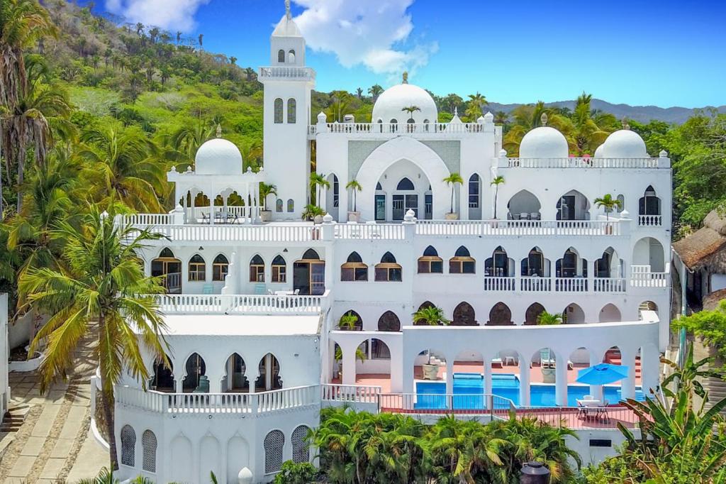 a large white building with palm trees in front of it at Villas Paradise in San Francisco