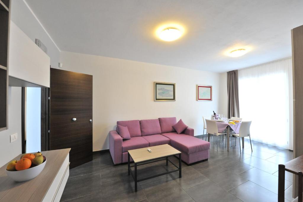 a living room with a pink couch and a table at Case Mistretta in Altavilla Milicia