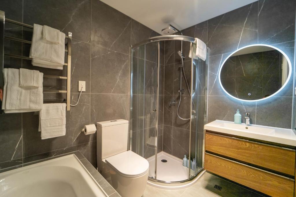 a bathroom with a shower and a toilet and a sink at Modern Sunnyhills Town House in Auckland