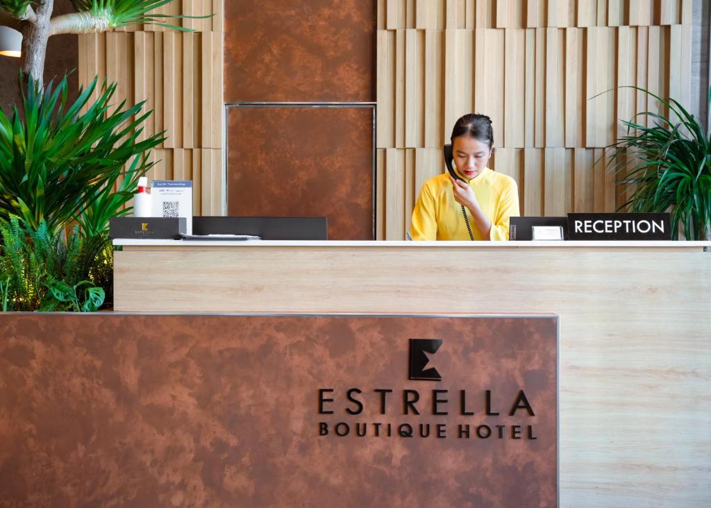 The hotel reception desk with wood detailing and indoor plants.