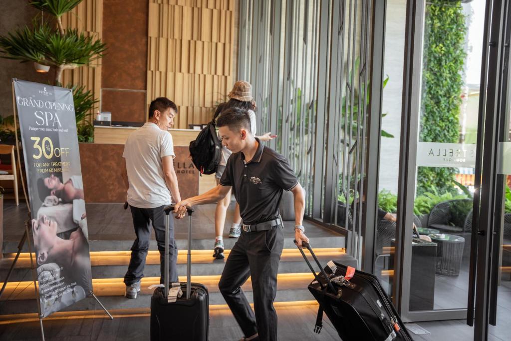 A hotel entrance scene with staff assisting guests and luggage.