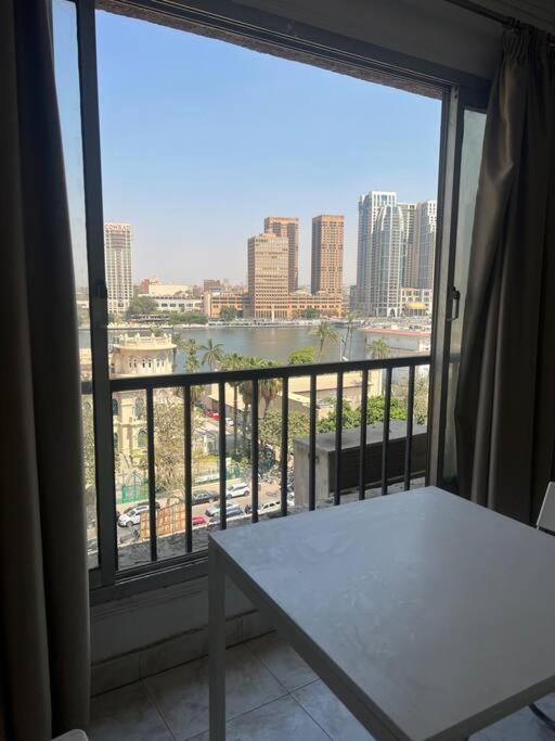 balcón con mesa y vistas a la ciudad en رواد الزمالك 2 إطلالة ع النيل و الابراج en El Cairo