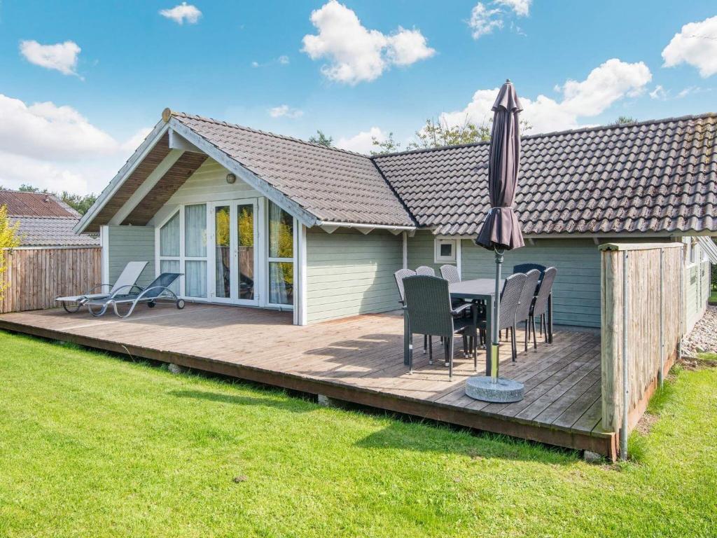 a wooden deck with a table and an umbrella at 8 person holiday home in Sydals-By Traum in Neder Lysabild