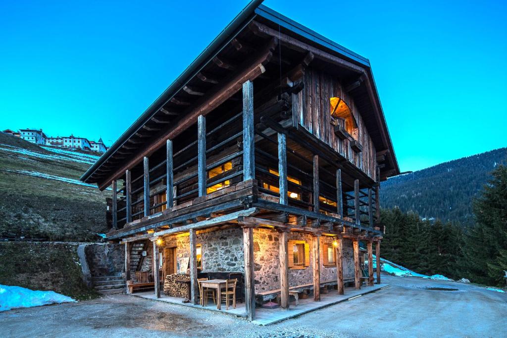 a large log cabin with a large window at Agriturismo Botondoro in San Nicol&ograve; di Comelico