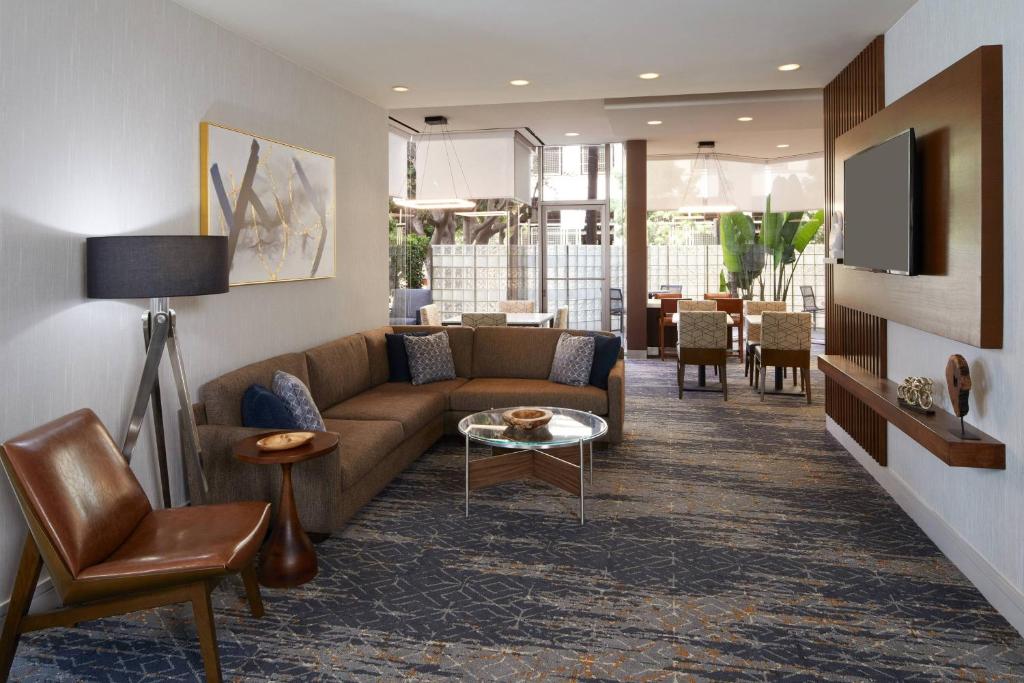 a living room with a couch and a table at Courtyard by Marriott Los Angeles LAX / Century Boulevard in Los Angeles