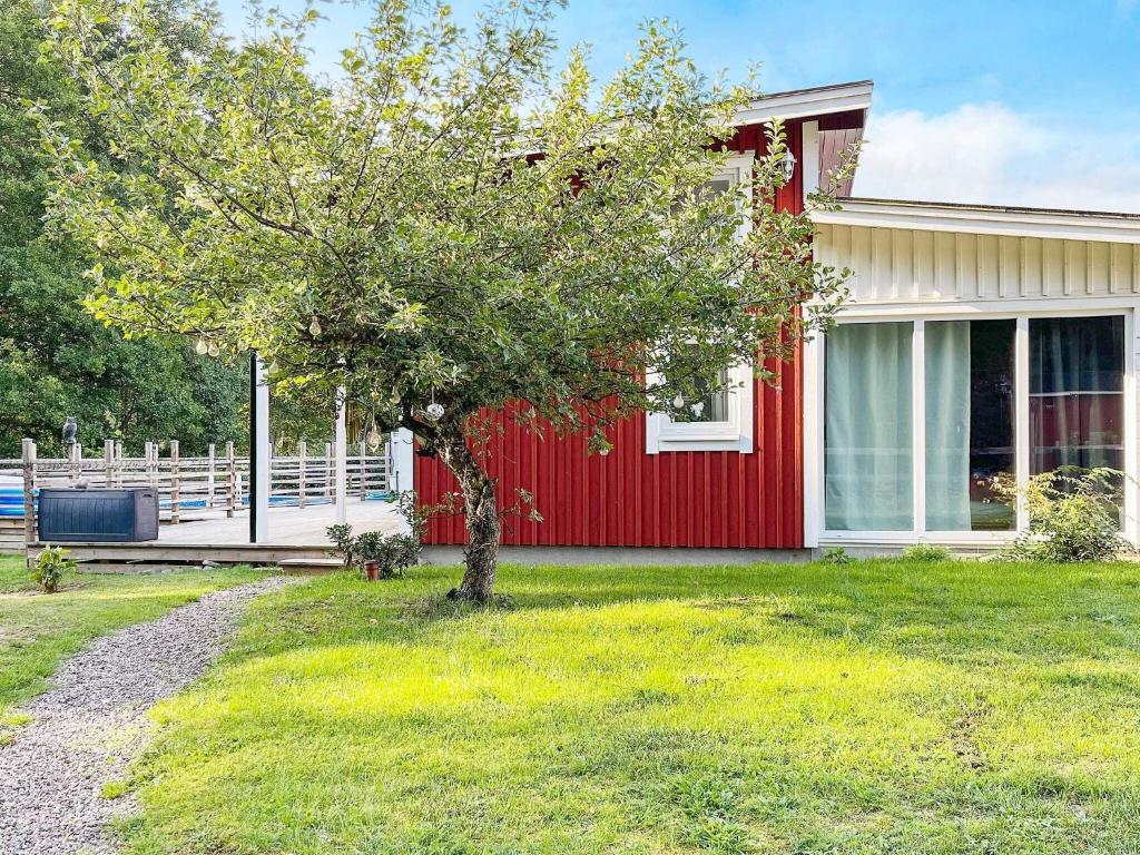 a red house with a tree in front of it at 3 person holiday home in NISSAFORS-By Traum in Böle