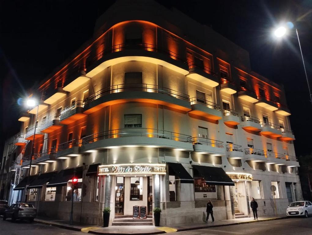 a large building with a balcony on a street at night at Hotel Viña de Italia in Cordoba