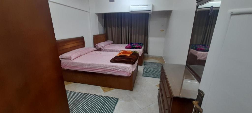 1 Schlafzimmer mit 2 Betten und rosa Bettwäsche in der Unterkunft 3 bedrooms apartment, Wi-Fi, in the quitest district in Assuan