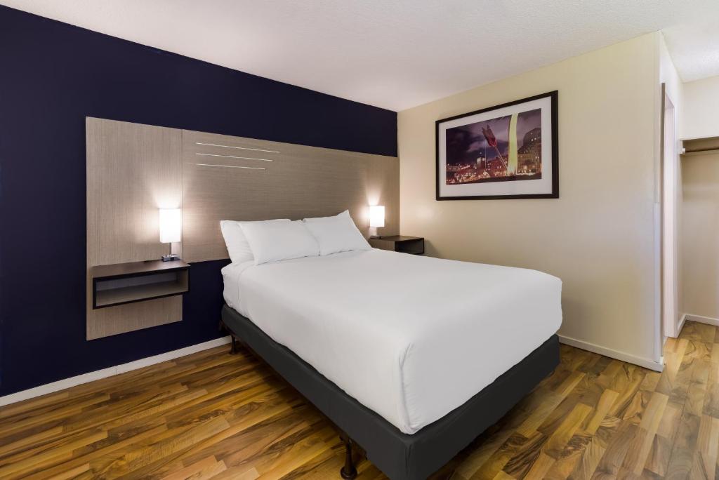 Ein Schlafzimmer mit einem großen weißen Bett und blauen Wänden in der Unterkunft Rodeway Inn Livermore in Livermore