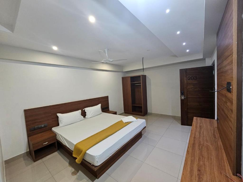 1 dormitorio con 1 cama grande y baño en Uptown Inn, en Ernakulam