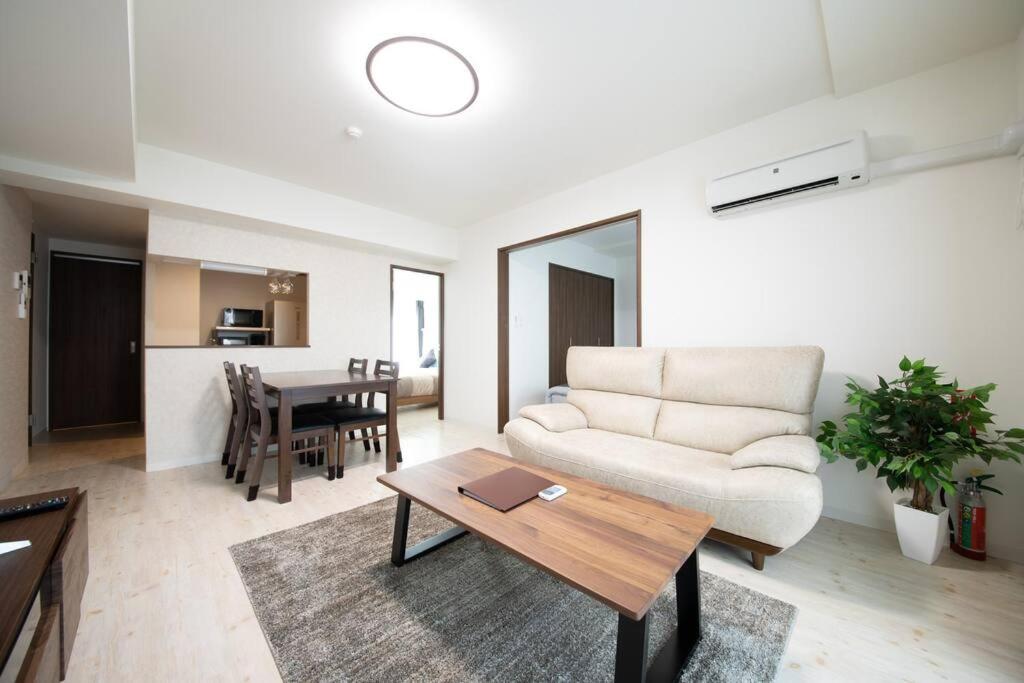 uma sala de estar com um sofá e uma mesa em Otaru SAMPO em Otaru