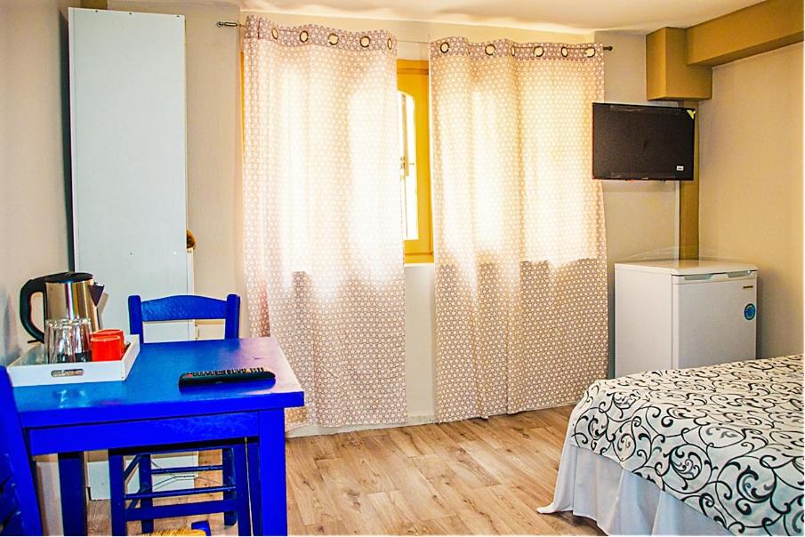 a bedroom with a blue desk and a bed and a television at smart Travellers in Thessaloniki