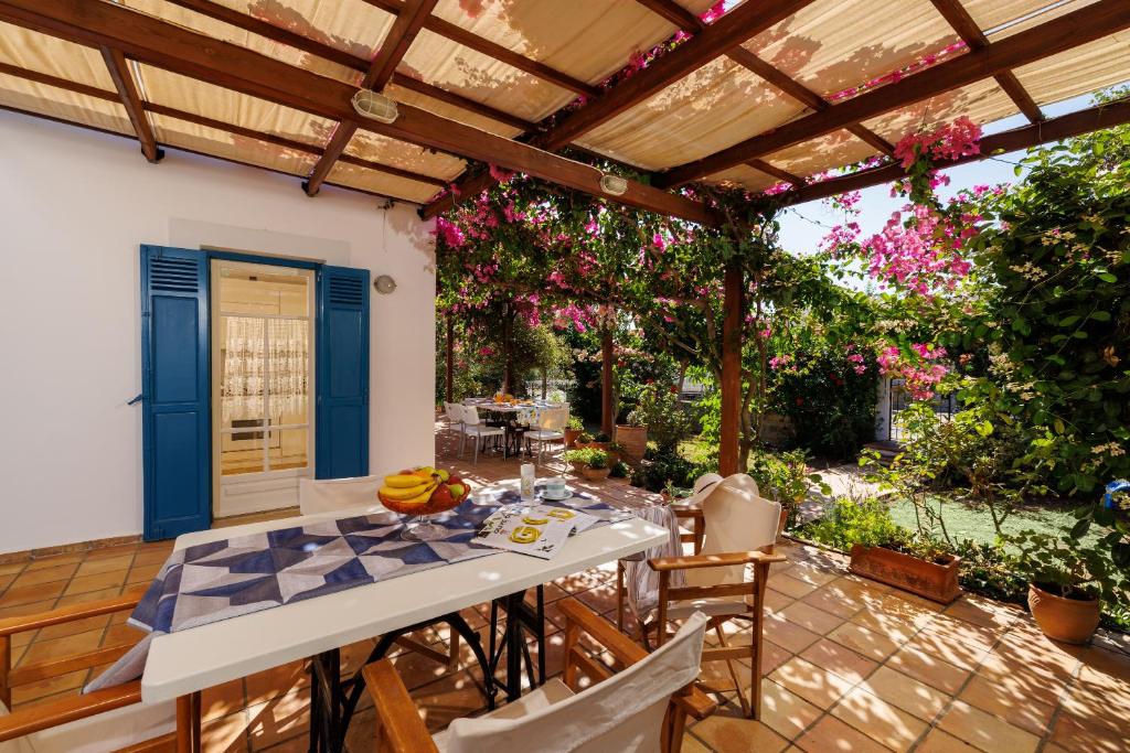 a patio with a table and chairs and a pergola at Villa in the Garden in Kokkini Khanion