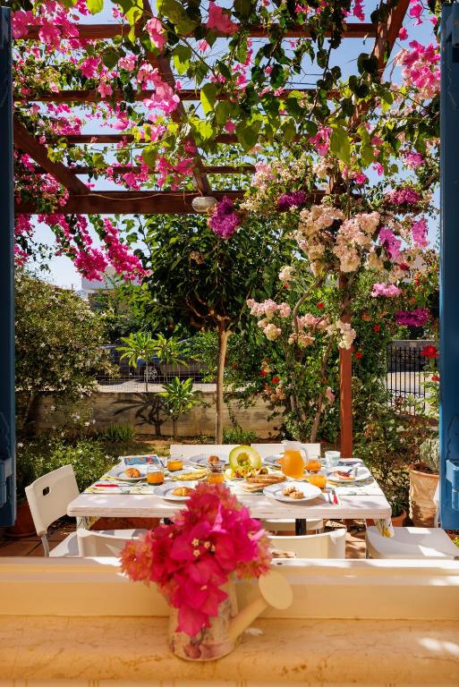 a table with plates of food and flowers on it at Villa in the Garden in Kokkini Khanion