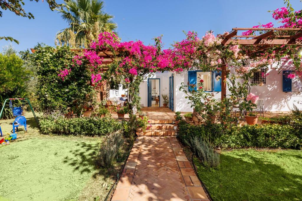 a house with pink flowers in the yard at Villa in the Garden in Kokkini Khanion