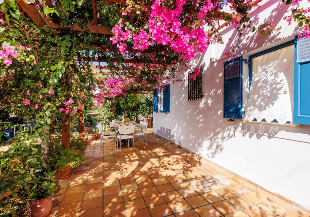 a patio with pink flowers and a table at Villa in the Garden in Kokkini Khanion