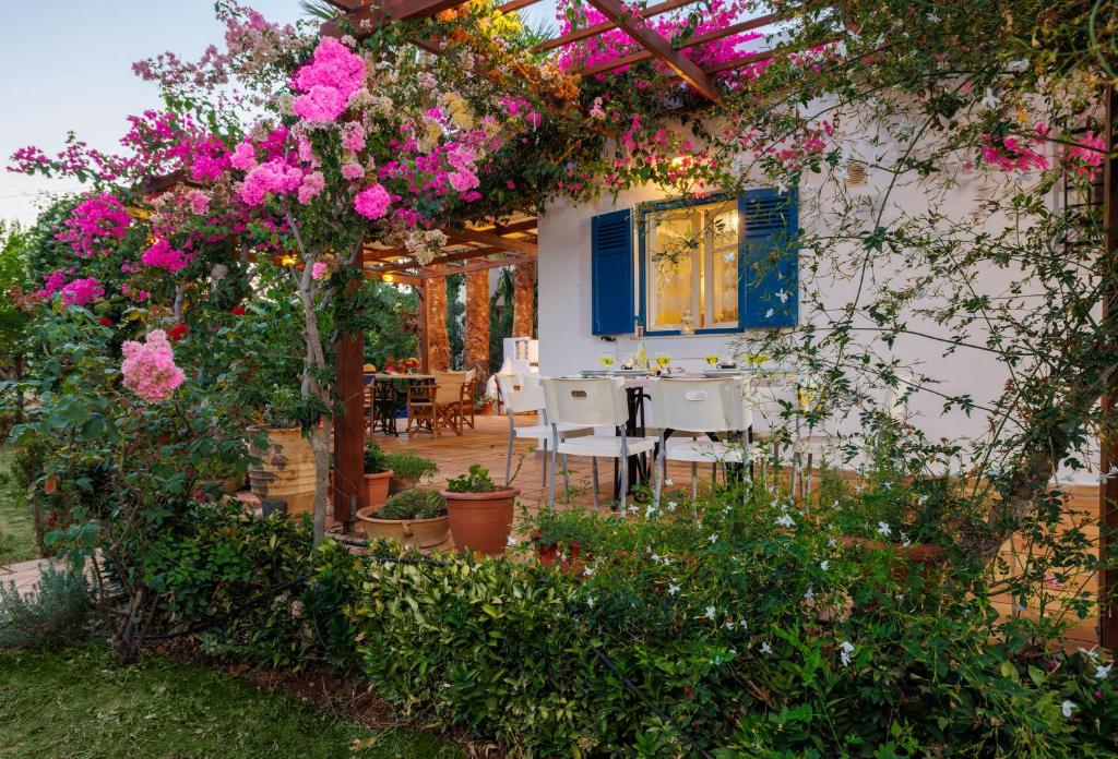 a garden with pink flowers and a table and chairs at Villa in the Garden in Kokkini Khanion