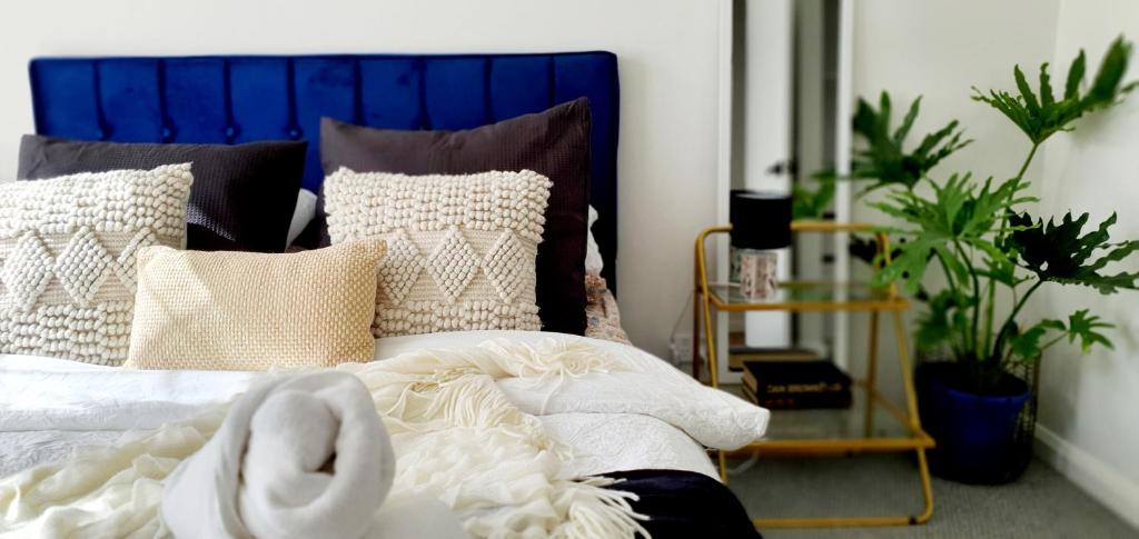 - une chambre avec un lit doté d'une tête de lit et d'oreillers bleus dans l'établissement Ballarat Holiday Homes - Hopetoun Cottage - Minutes from Ballarat CBD - Sleeps 1 to 6, à Ballarat