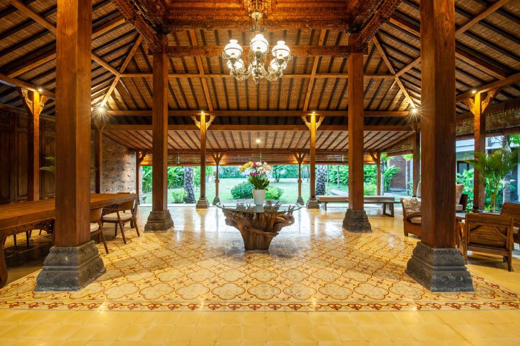 a large pavilion with a table and a chandelier at Griya Shanti Suites in Sanur